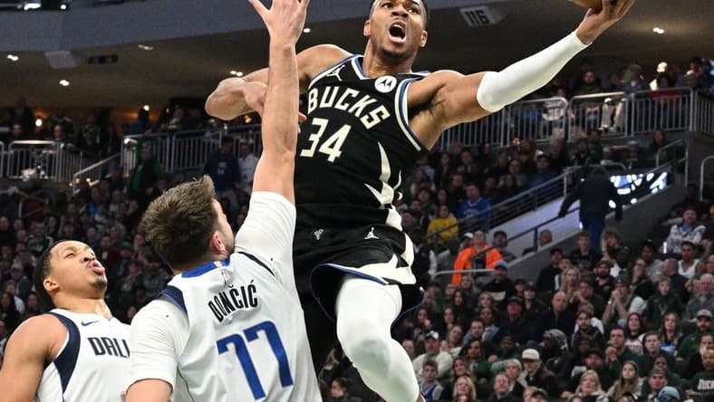 Nov 18, 2023; Milwaukee, Wisconsin, USA; Milwaukee Bucks forward Giannis Antetokounmpo (34) drives to the basket against Dallas Mavericks guard Luka Doncic (77) in the first half at Fiserv Forum. Mandatory Credit: Michael McLoone-USA TODAY Sports