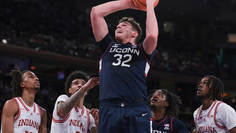 Nov 19, 2023; New York, New York, USA; Connecticut Huskies center Donovan Clingan (32) goes to the basket in front of Indiana Hoosiers center Kel'el Ware (1) and forward Mackenzie Mgbako (21) and guard Gabe Cupps (2) during the first half at Madison Square Garden. Mandatory Credit: Vincent Carchietta-USA TODAY Sports