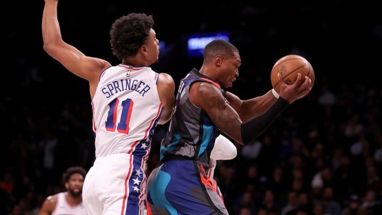 Nov 19, 2023; Brooklyn, New York, USA; Brooklyn Nets guard Lonnie Walker IV (8) grabs a rebound against Philadelphia 76ers guard Jaden Springer (11) during the first quarter at Barclays Center. Mandatory Credit: Brad Penner-USA TODAY Sports