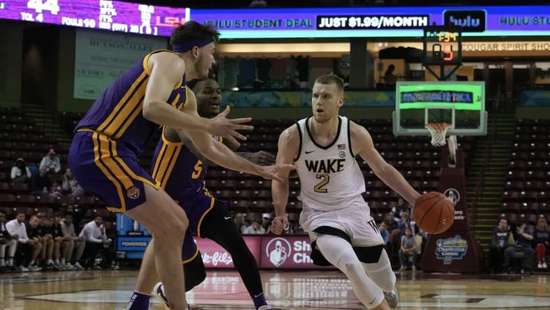 Nov 19, 2023; Charleston, SC, USA; Wake Forest Demon Deacons guard Cameron Hildreth (2) drives the ball around LSU Tigers forward Will Baker (9) in the first half at TD Arena. Mandatory Credit: David Yeazell-USA TODAY Sports