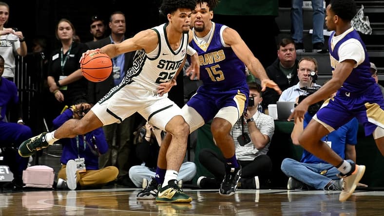 Nov 19, 2023; East Lansing, Michigan, USA;  Michigan State Spartans forward Malik Hall (25) drives past Alcorn State Braves forward Djahi Binet (15) during the first half at Jack Breslin Student Events Center. Mandatory Credit: Dale Young-USA TODAY Sports
