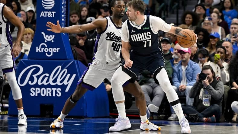 Nov 19, 2023; Dallas, Texas, USA; Dallas Mavericks guard Luka Doncic (77) looks to move the ball past Sacramento Kings forward Harrison Barnes (40) during the second half at the American Airlines Center. Mandatory Credit: Jerome Miron-USA TODAY Sports