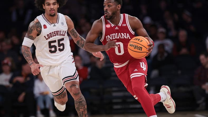 Nov 20, 2023; New York, NY, USA; Indiana Hoosiers guard Xavier Johnson (0) dribbles up court in front of Louisville Cardinals guard Skyy Clark (55) during the second half at Madison Square Garden. Mandatory Credit: Vincent Carchietta-USA TODAY Sports