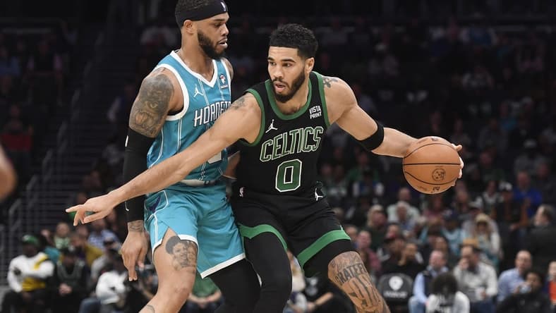 Nov 20, 2023; Charlotte, North Carolina, USA; Boston Celtics forward Jayson Tatum (0) looks to drive past Charlotte Hornets forward Miles Bridges (0) during the first half at the Spectrum Center. Mandatory Credit: Sam Sharpe-USA TODAY Sports