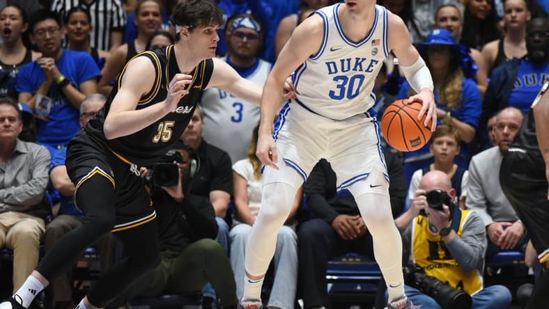 Nov 21, 2023; Durham, North Carolina, USA; Duke Blue Devils center Kyle Filipowski (30) controls the ball in front of La Salle Explorers forward Rokas Jucius (35) during the first half at Cameron Indoor Stadium. Mandatory Credit: Rob Kinnan-USA TODAY Sports