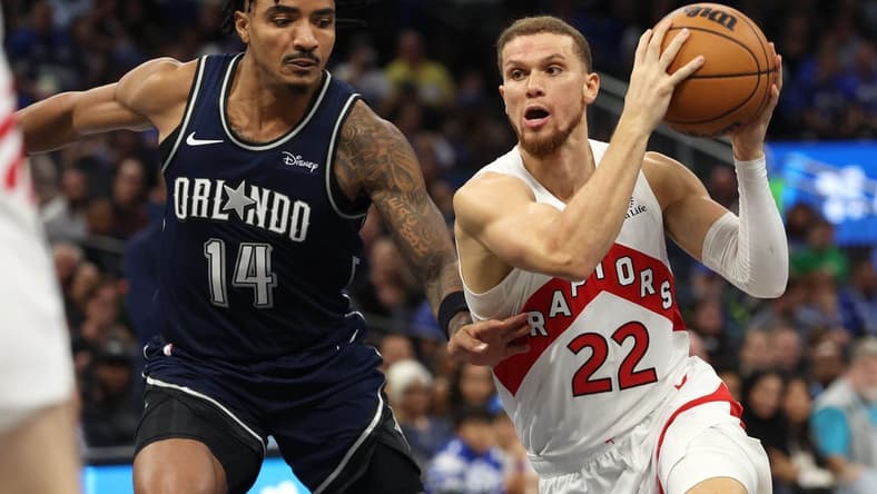 Nov 21, 2023; Orlando, Florida, USA;Toronto Raptors guard Malachi Flynn (22) drives to the basket as Orlando Magic guard Gary Harris (14) defends  during the second half at Amway Center. Mandatory Credit: Kim Klement Neitzel-USA TODAY Sports