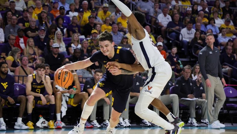 Nov 22, 2023; Fort Myers, FL, USA;  West Virginia Mountaineers forward Quinn Slazinski (11) drives to the hoop past Virginia Cavaliers guard Ryan Dunn (13) in the second half during the Fort Myers Tip-Off third place game at Suncoast Credit Union Arena. Mandatory Credit: Nathan Ray Seebeck-USA TODAY Sports