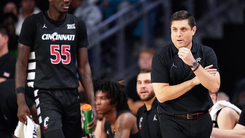 Cincinnati Bearcats head coach Wes Miller paces the sideline as Cincinnati Bearcats forward Aziz Bandaogo (55) finds a seat on the bench in the first half during an NCAA college basketball game between Georgia Tech Yellow Jackets and the Cincinnati Bearcats, Wednesday, Nov. 22, 2023, at Fifth Third Arena in Cincinnati.