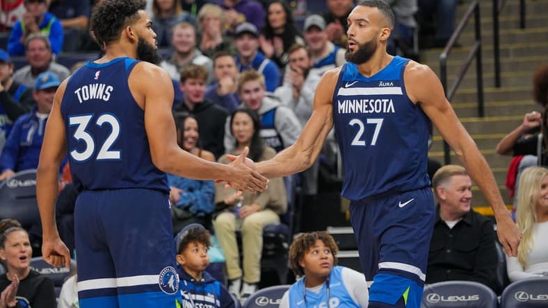 Nov 22, 2023; Minneapolis, Minnesota, USA; Minnesota Timberwolves center Karl-Anthony Towns (32) congratulates center Rudy Gobert (27) against the Philadelphia 76ers in the third quarter at Target Center. Mandatory Credit: Brad Rempel-USA TODAY Sports