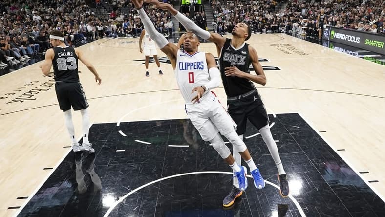 Nov 22, 2023; San Antonio, Texas, USA; Los Angeles Clippers guard Russell Westbrook (0) lays in a basket while defended by San Antonio Spurs forward Victor Wembanyama (1) during the second half at Frost Bank Center. Mandatory Credit: Scott Wachter-USA TODAY Sports