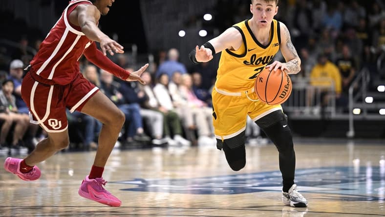 Nov 23, 2023; La Jolla, California, USA; Iowa Hawkeyes guard Brock Harding (2) dribbles the ball while defended by Oklahoma Sooners guard Javian McCollum (2) during the first half at LionTree Arena. Mandatory Credit: Orlando Ramirez-USA TODAY Sports