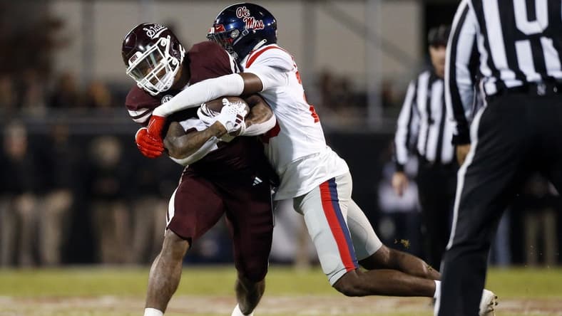 Nov 23, 2023; Starkville, Mississippi, USA; Mississippi State Bulldogs running back Jeffery Pittman (25) runs the ball as Mississippi Rebels linebacker Khari Coleman (23) makes the tackle during the first half at Davis Wade Stadium at Scott Field. Mandatory Credit: Petre Thomas-USA TODAY Sports