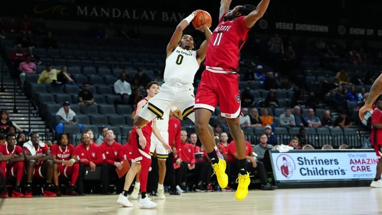 Nov 23, 2023; Las Vegas, Nevada, USA; Vanderbilt Commodores guard Tyrin Lawrence (0) shoots against North Carolina State Wolfpack guard Dennis Parker Jr. (11) during the first half at Michelob Ultra Arena. Mandatory Credit: Stephen R. Sylvanie-USA TODAY Sports