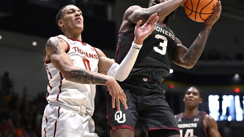 Nov 24, 2023; La Jolla, California, USA; Oklahoma Sooners guard Otega Oweh (3) goes to the basket while defended by USC Trojans guard Kobe Johnson (0) during the second half at LionTree Arena. Mandatory Credit: Orlando Ramirez-USA TODAY Sports