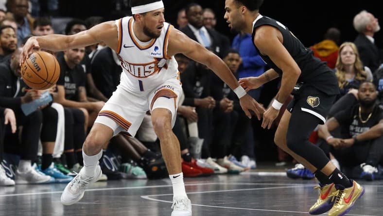 Nov 24, 2023; Memphis, Tennessee, USA; Phoenix Suns guard Devin Booker (1) dribbles as Memphis Grizzlies guard Jacob Gilyard (0) defends during the second half at FedExForum. Mandatory Credit: Petre Thomas-USA TODAY Sports