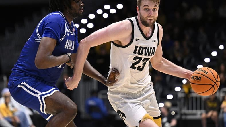 Nov 24, 2023; La Jolla, California, USA; Iowa Hawkeyes forward Ben Krikke (23) dribbles the ball while defended by Seton Hall Pirates center Jaden Bediako (15) during the first half at LionTree Arena. Mandatory Credit: Orlando Ramirez-USA TODAY Sports