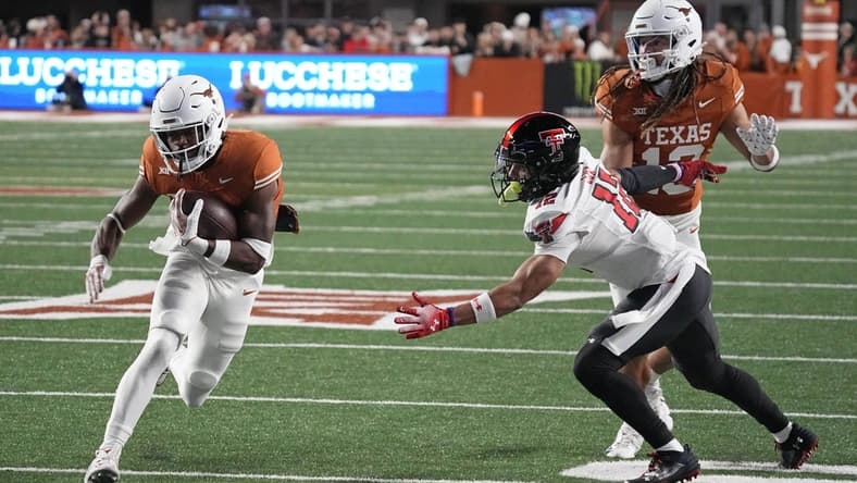 Nov 24, 2023; Austin, Texas, USA; Texas Longhorns running back Keilan Robinson (7) runs for a touchdown while defended by Texas Tech Red Raiders defensive back Bralyn Lux (12) during the first half at Darrell K Royal-Texas Memorial Stadium. Mandatory Credit: Scott Wachter-USA TODAY Sports