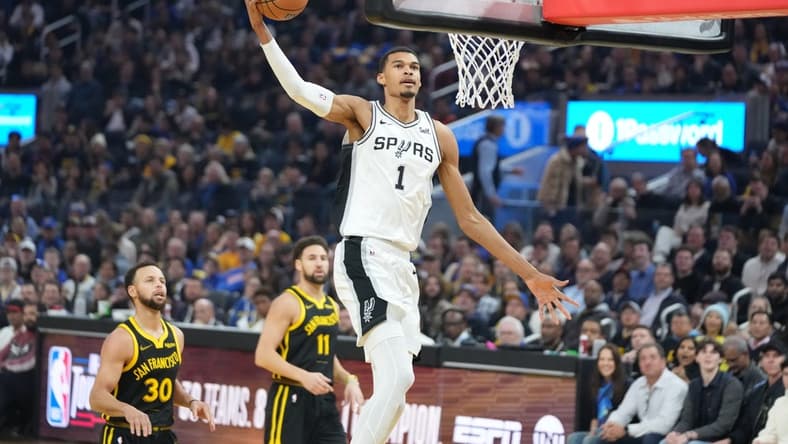 November 24, 2023; San Francisco, California, USA; San Antonio Spurs center Victor Wembanyama (1) dunks the basketball against Golden State Warriors guard Stephen Curry (30) and guard Klay Thompson (11) during the first quarter at Chase Center. Mandatory Credit: Kyle Terada-USA TODAY Sports