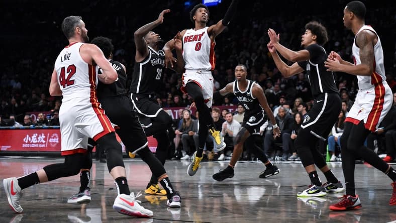 Nov 25, 2023; Brooklyn, New York, USA; Miami Heat guard Josh Richardson (0) drives to the basket against Brooklyn Nets forward Dorian Finney-Smith (28) and  guard Lonnie Walker IV (8) and forward Cameron Johnson (2) during the second quarter at Barclays Center. Mandatory Credit: John Jones-USA TODAY Sports