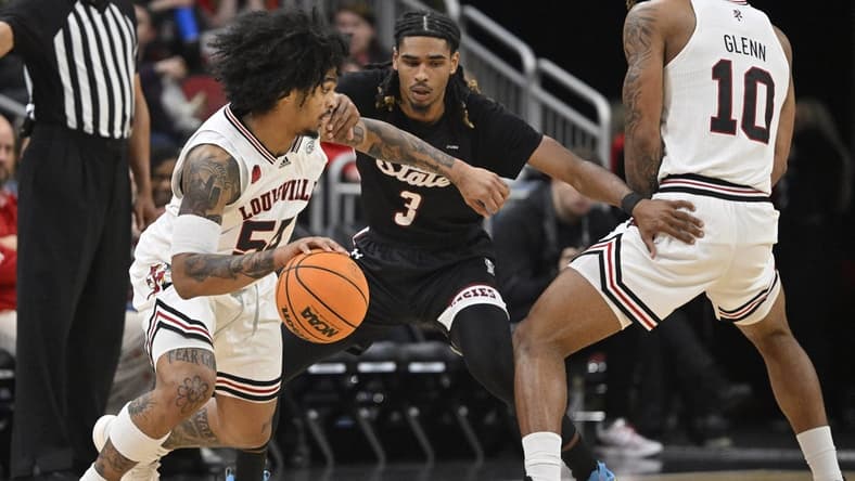 Nov 26, 2023; Louisville, Kentucky, USA; Louisville Cardinals guard Skyy Clark (55) dribbles against New Mexico State Aggies guard Christian Cook (3) during the first half at KFC Yum! Center. Mandatory Credit: Jamie Rhodes-USA TODAY Sports