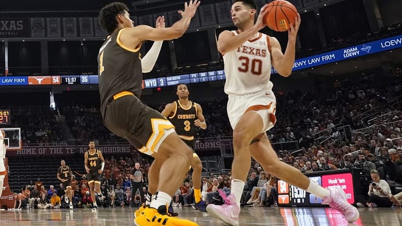 Nov 26, 2023; Austin, Texas, USA; Texas Longhorns forward Brock Cunningham (30) drives to the basket while defended by Wyoming Cowboys guard Brendan Wenzel (1) during the second half at Moody Center. Mandatory Credit: Scott Wachter-USA TODAY Sports