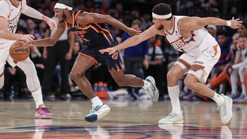 Nov 26, 2023; New York, New York, USA; New York Knicks guard Immanuel Quickley (5) steals the ball from Phoenix Suns guard Devin Booker (1) in the fourth quarter at Madison Square Garden. Mandatory Credit: Wendell Cruz-USA TODAY Sports