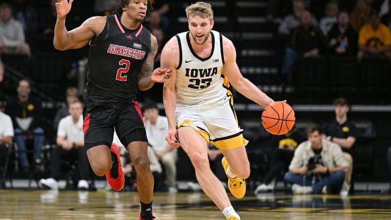 Nov 17, 2023; Iowa City, Iowa, USA; Iowa Hawkeyes forward Ben Krikke (23) controls the ball as Arkansas State Red Wolves guard Freddy Hicks (2) defends during the first half at Carver-Hawkeye Arena. Mandatory Credit: Jeffrey Becker-USA TODAY Sports