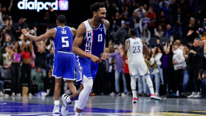 Nov 28, 2023; Sacramento, California, USA; Sacramento Kings guard Malik Monk (0) smiles after scoring a basket during the fourth quarter against the Golden State Warriors at Golden 1 Center. Mandatory Credit: Sergio Estrada-USA TODAY Sports