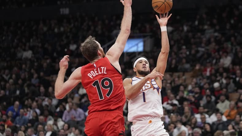 Nov 29, 2023; Toronto, Ontario, CAN; Phoenix Suns guard Devin Booker (1) shoots the ball as Toronto Raptors center Jakob Poeltl (19) defends during the first half at Scotiabank Arena. Mandatory Credit: John E. Sokolowski-USA TODAY Sports