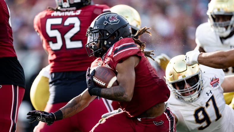 Dec 30, 2022; Jacksonville, FL, USA; South Carolina Gamecocks wide receiver Antwane Wells Jr. (3) runs with the ball away from Notre Dame Fighting Irish defensive lineman Gabriel Rubio (97) during the first half in the 2022 Gator Bowl at TIAA Bank Field. Mandatory Credit: Matt Pendleton-USA TODAY Sports