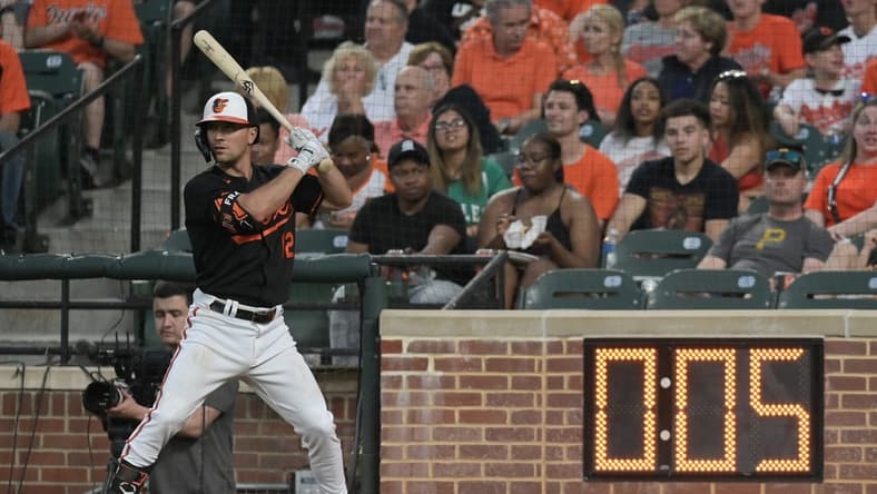 May 12, 2023; Baltimore, Maryland, USA; Baltimore Orioles second baseman Adam Frazier (12) warms up next to the pitch clock during the third inning of the game against the Pittsburgh Pirates at Oriole Park at Camden Yards. Mandatory Credit: Tommy Gilligan-USA TODAY Sports