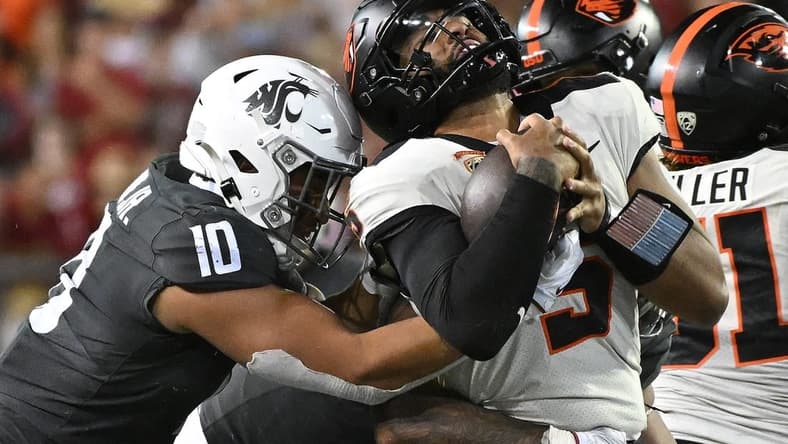 Sep 23, 2023; Pullman, Washington, USA; Oregon State Beavers quarterback DJ Uiagalelei (5) is stopped by Washington State Cougars defensive end Ron Stone Jr. (10) in the second half at Gesa Field at Martin Stadium. Mandatory Credit: James Snook-USA TODAY Sports