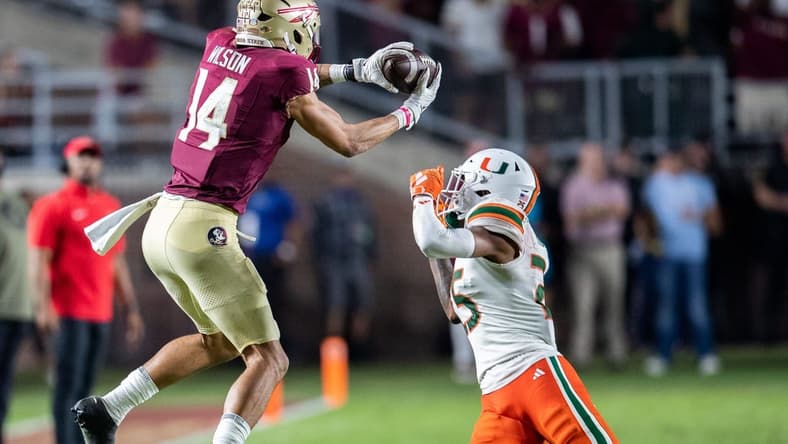 Florida State Seminoles wide receiver Johnny Wilson (14) catches a pass from Florida State Seminoles quarterback Jordan Travis (13). The Florida State Seminoles defeated the Miami Hurricanes 27-20 on Saturday, Nov. 11, 2023.