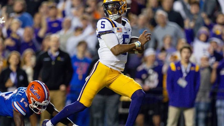 Nov 11, 2023; Baton Rouge, Louisiana, USA; LSU Tigers quarterback Jayden Daniels (5) rushes for a touchdown against Florida Gators safety Jordan Castell (14) during the first half at Tiger Stadium. Mandatory Credit: Stephen Lew-USA TODAY Sports