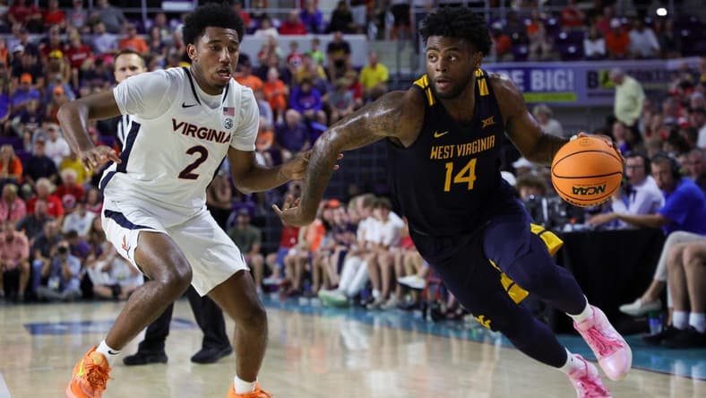 Nov 22, 2023; Fort Myers, FL, USA; West Virginia Mountaineers guard Seth Wilson (14) drives past Virginia Cavaliers guard Reece Beekman (2) in the second half during the Fort Myers Tip-Off third place game at Suncoast Credit Union Arena. Mandatory Credit: Nathan Ray Seebeck-USA TODAY Sports