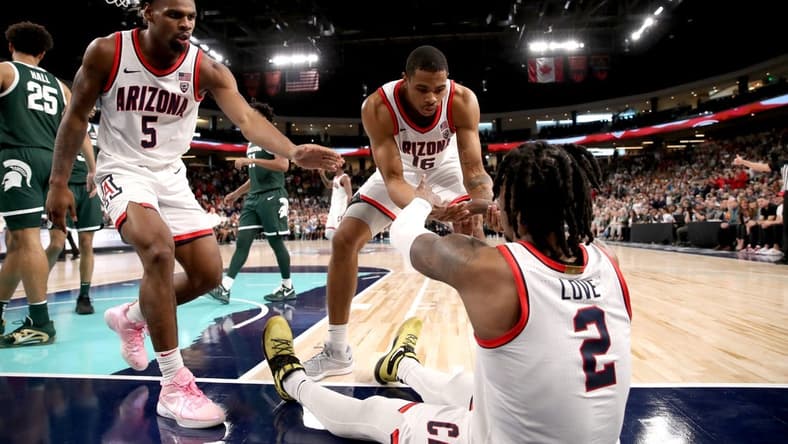 Arizona Wildcats guard KJ Lewis (5), left, and Arizona Wildcats forward Keshad Johnson (16) help Arizona Wildcats guard Caleb Love (2) to his feet during the Acrisure Classic.