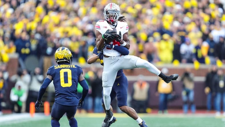 Ohio State wide receiver Marvin Harrison Jr. makes a catch against Michigan defensive backs Quinten Johnson and Mike Sainristil during the second half at Michigan Stadium in Ann Arbor on Saturday, Nov. 25, 2023.