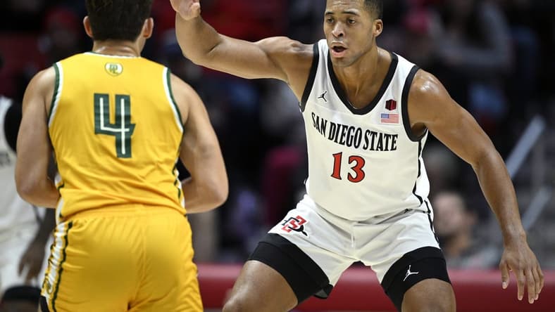 Nov 27, 2023; San Diego, California, USA; San Diego State Aztecs forward Jaedon LeDee (13) defends Point Loma Nazarene Sea Lions guard Coby Barnes (4) during the first half at Viejas Arena. Mandatory Credit: Orlando Ramirez-USA TODAY Sports
