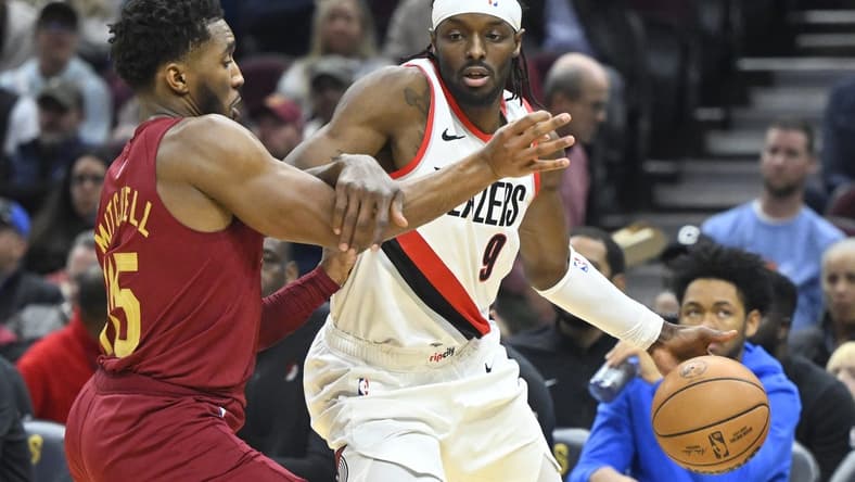 Nov 30, 2023; Cleveland, Ohio, USA; Portland Trail Blazers forward Jerami Grant (9) drives against Cleveland Cavaliers guard Donovan Mitchell (45) in the second quarter at Rocket Mortgage FieldHouse. Mandatory Credit: David Richard-USA TODAY Sports