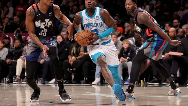 Nov 30, 2023; Brooklyn, New York, USA; Charlotte Hornets guard Terry Rozier (3) drives to the basket against Brooklyn Nets center Nic Claxton (33) and forward Dorian Finney-Smith (28) during the fourth quarter at Barclays Center. Mandatory Credit: Brad Penner-USA TODAY Sports