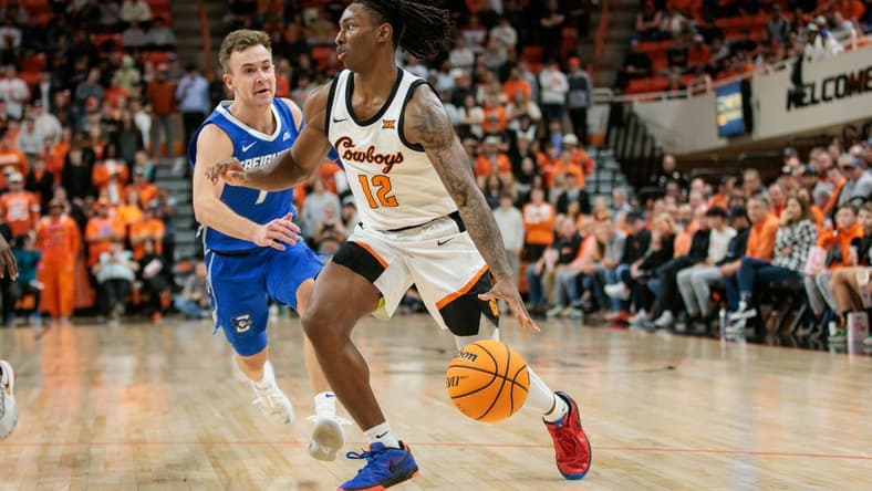 Nov 30, 2023; Stillwater, Oklahoma, USA; Oklahoma State Cowboys guard Javon Small (12) drives to the basket around Creighton Bluejays guard Steven Ashworth (1) during the first half at Gallagher-Iba Arena. Mandatory Credit: William Purnell-USA TODAY Sports