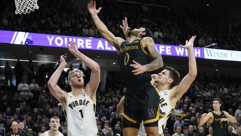 Dec 1, 2023; Evanston, Illinois, USA; Purdue Boilermakers forward Caleb Furst (1) defends Northwestern Wildcats guard Boo Buie (0) during the second half at Welsh-Ryan Arena. Mandatory Credit: David Banks-USA TODAY Sports