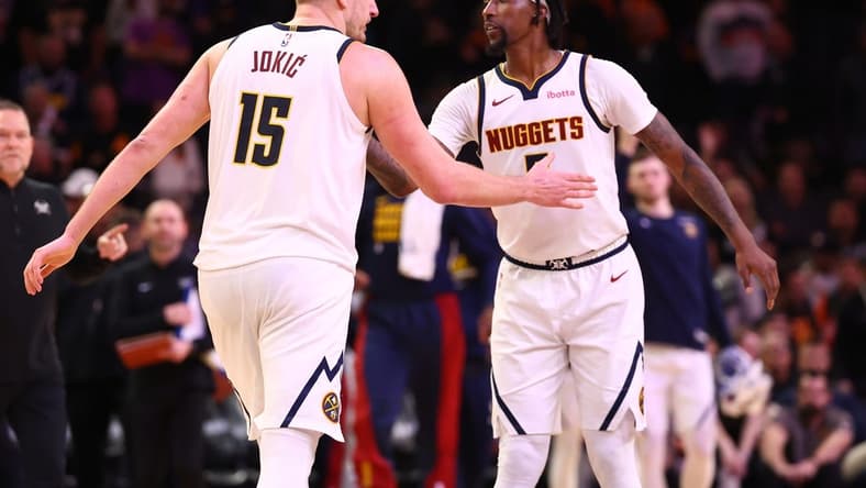Dec 1, 2023; Phoenix, Arizona, USA; Denver Nuggets center Nikola Jokic (15) celebrates with guard Kentavious Caldwell-Pope (5) against the Phoenix Suns in the second half at Footprint Center. Mandatory Credit: Mark J. Rebilas-USA TODAY Sports
