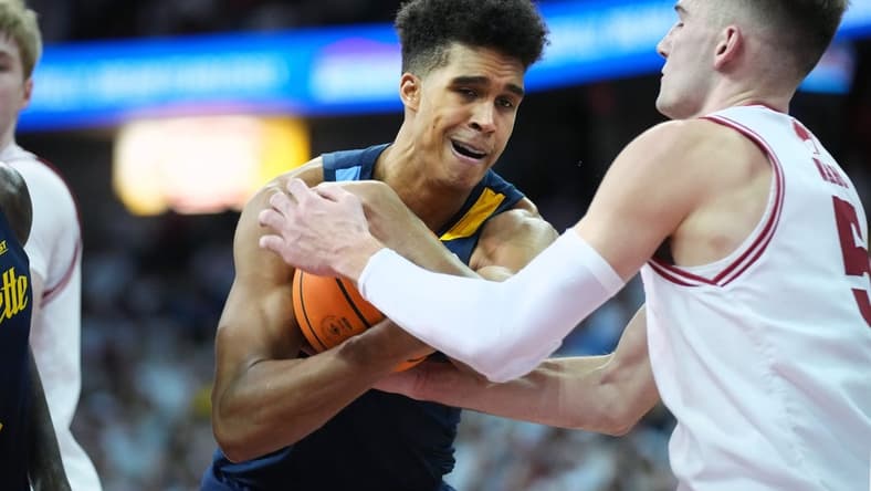 Dec 2, 2023; Madison, Wisconsin, USA; Marquette Golden Eagles forward Oso Ighodaro (13) and Wisconsin Badgers forward Tyler Wahl (5) battle for the ball during the second half at the Kohl Center. Mandatory Credit: Kayla Wolf-USA TODAY Sports