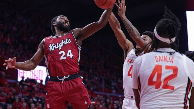 Dec 2, 2023; Piscataway, New Jersey, USA; Rutgers Scarlet Knights guard Austin Williams (24) rebounds against Illinois Fighting Illini guard Justin Harmon (4) and forward Dain Dainja (42) during the first half at Jersey Mike's Arena. Mandatory Credit: Vincent Carchietta-USA TODAY Sports