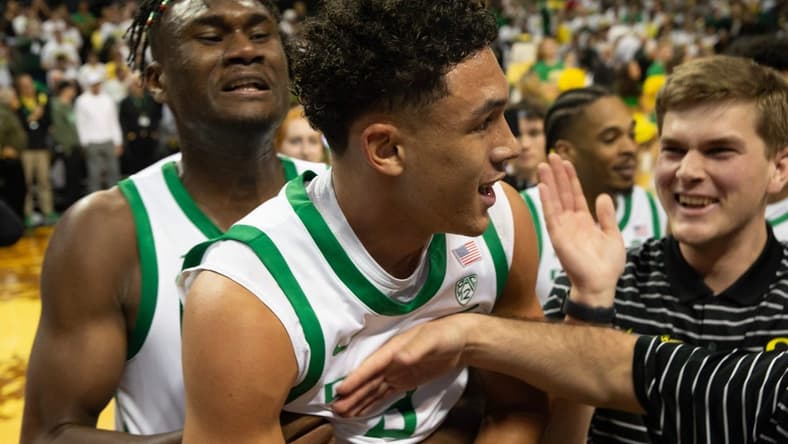 Oregon s Jackson Shelstad, center, is mobbed by teammates after sinking the game winning shot against Michigan in overtime at Matthew Knight Arena in Eugene Saturday, Dec 2, 2023.