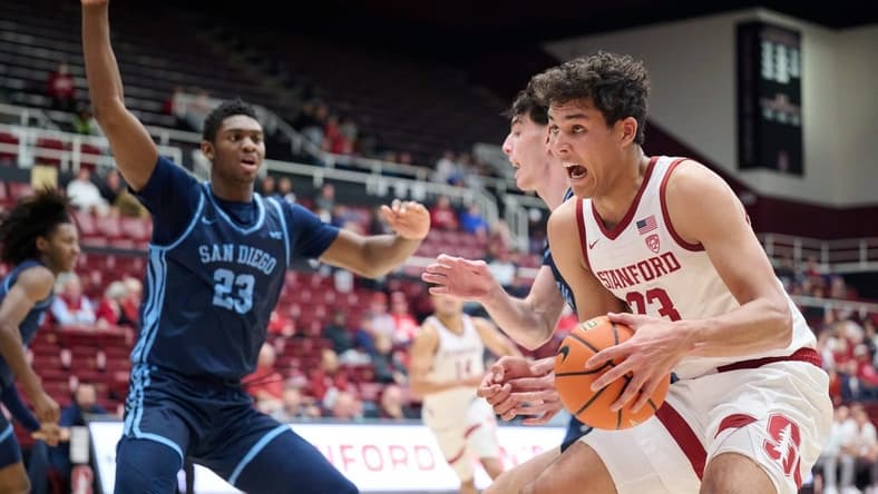 Dec 3, 2023; Stanford, California, USA; Stanford Cardinal forward Brandon Angel (23) controls the ball against San Diego Toreros forward Jimmy Oladokun Jr. (23) during the first half at Maples Pavilion. Mandatory Credit: Robert Edwards-USA TODAY Sports