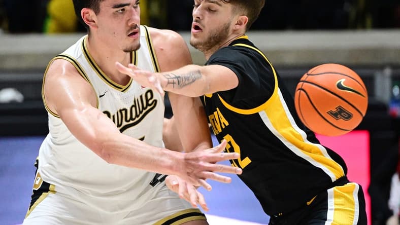 Dec 4, 2023; West Lafayette, Indiana, USA; Purdue Boilermakers center Zach Edey (15) passes the ball past Iowa Hawkeyes forward Owen Freeman (32) during the first half at Mackey Arena. Mandatory Credit: Marc Lebryk-USA TODAY Sports