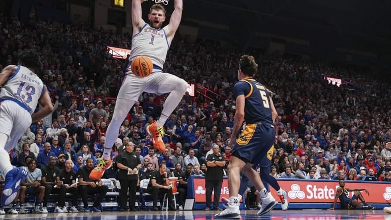 Dec 5, 2023; Lawrence, Kansas, USA; Kansas Jayhawks center Hunter Dickinson (1) dunks the ball as UMKC Kangaroos guard Jamar Brown (5) looks on during the first half at Allen Fieldhouse. Mandatory Credit: Denny Medley-USA TODAY Sports