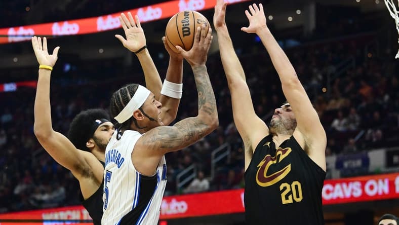 Dec 6, 2023; Cleveland, Ohio, USA; Orlando Magic forward Paolo Banchero (5) drives to the basket between Cleveland Cavaliers center Jarrett Allen (31) and forward Georges Niang (20) during the first half at Rocket Mortgage FieldHouse. Mandatory Credit: Ken Blaze-USA TODAY Sports